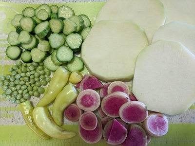 Beautiful plate of colorful cut vegetables--cucumbers, kohlrabi, peas, peppers and radish